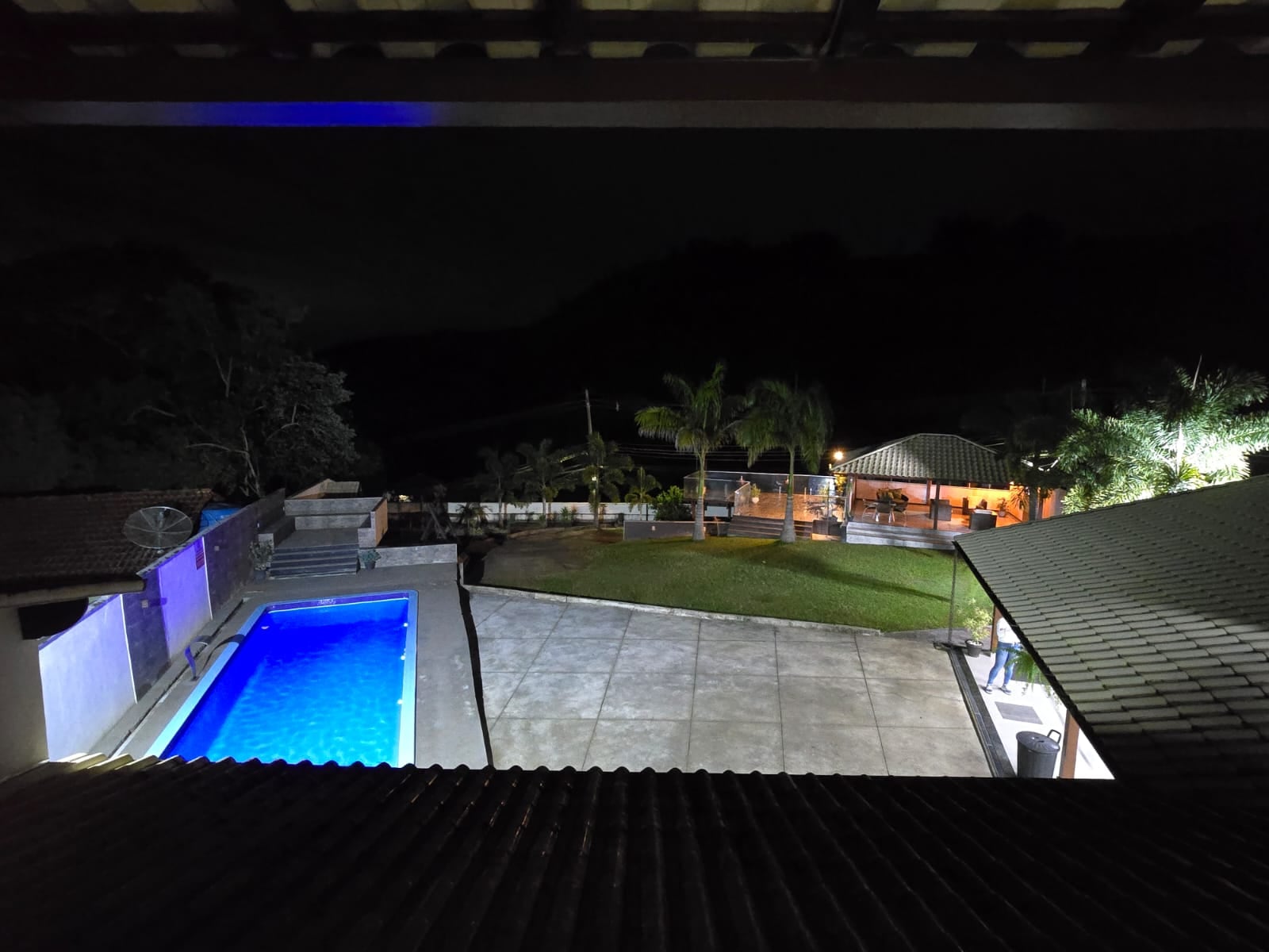 Piscina e jardim iluminados à noite